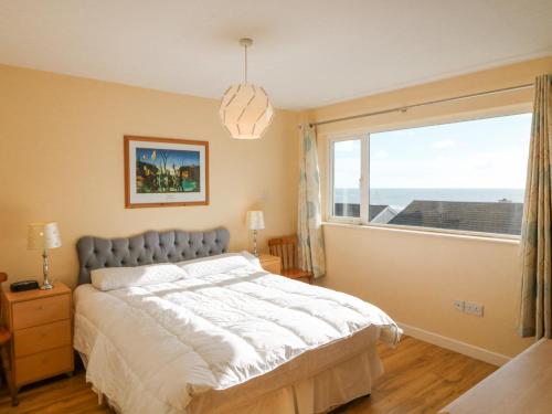 um quarto com uma cama e uma grande janela em Sea's The Dream em Clonakilty