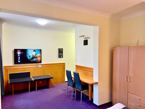 a waiting room with a table and chairs at LAS SŁUPSKI APARTAMENTY PREMIUM Wifi Netflix Smart TV50 Wysoka Jakość za Niską Cenę Zapraszamy in Słupsk