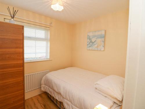 a small bedroom with a bed and a window at Sea's The Dream in Clonakilty