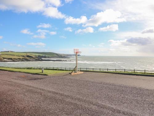 a road with a basketball hoop next to the ocean at Sea's The Dream in Clonakilty