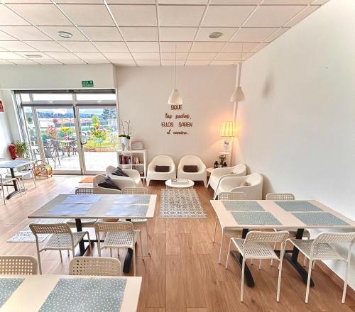 un restaurante con mesas y sillas en una habitación en Albergue Melide, en Melide