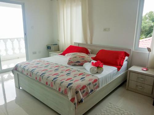 a bedroom with a bed with red pillows at Reve Blêu in Glacis