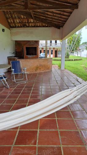 a bed on a patio with a table and a chair at Casa Pé na Areia Cantão do Bora Bora - Manaaki Surf Hostel in São Sebastião