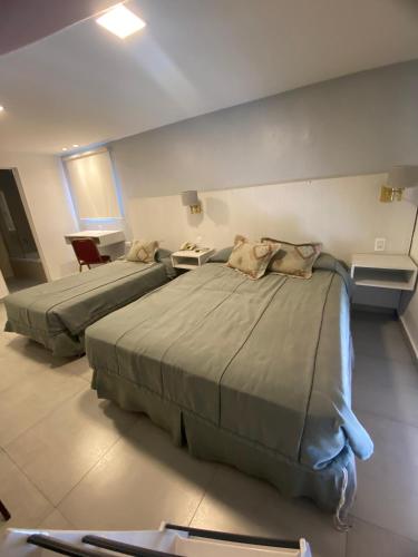 two beds in a hotel room with two bedsvisor at Hotel Metropol in San Miguel de Tucumán