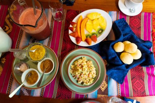 a table with plates of food and fruit on it at Casa Divina Eco Lodge in Mindo