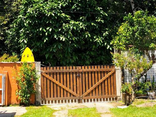 a wooden gate in front of a tree at Casa Pé na Areia Cantão do Bora Bora - Manaaki Surf Hostel in São Sebastião