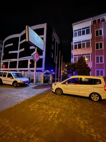 two white cars parked on a street at night at AYDIN APART HOTEL in Balıkesir
