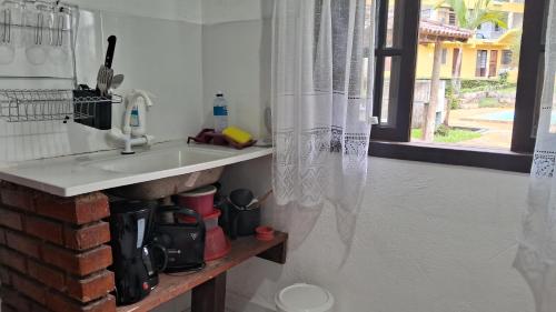 a kitchen counter with a sink and a window at Chalé do riacho 2 in Penedo
