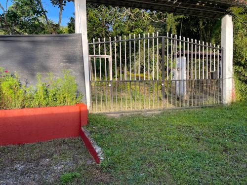a red bench sitting in front of a fence at Casa Campestre Finca Villa Amparo in Silvania
