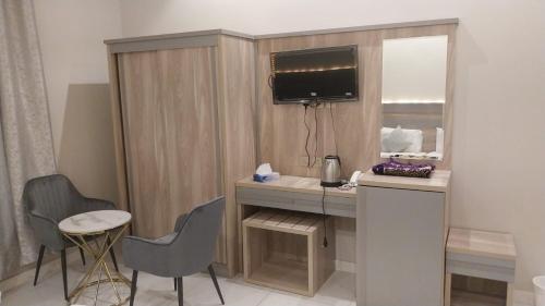 Habitación pequeña con escritorio y espejo. en فندق الروابط نفحات الحرم سابقا, en La Meca