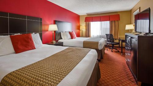 Habitación de hotel con 2 camas y TV en Hemp Hotel, en Oklahoma City