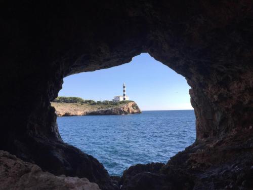 a cave with a view of the ocean and a lighthouse at Pierre&Vacances Mallorca Portofino in Santa Ponsa