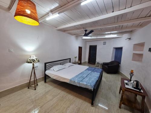 een slaapkamer met een bed, een tafel en een lamp bij The Red Soil Country in Siuri
