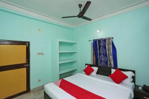 - une chambre avec un lit et un ventilateur de plafond dans l'établissement Hotel Madison Patia Inn Bhubaneswar, à Bhubaneswar