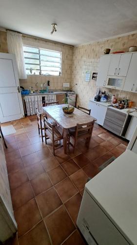cocina con mesa y sillas en una habitación en Casa Pé na Areia Cantão do Bora Bora - Manaaki Surf Hostel en São Sebastião