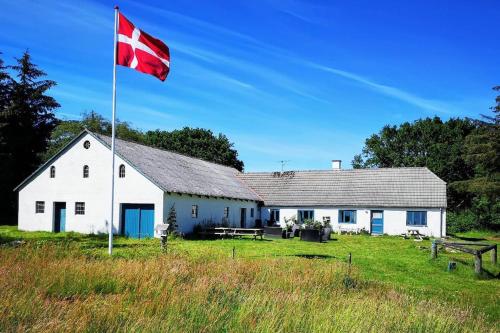a canadian flag flying in front of a white building at Glædegården -Glaede Landhof- 12 beds! in Frøstrup