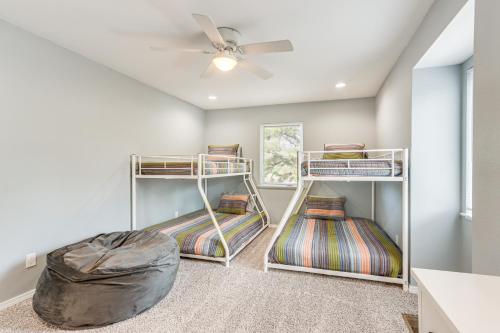 a room with three bunk beds and a ceiling fan at Spacious Arkansas Retreat with Deck, Hot Tub and Grill in Rogers
