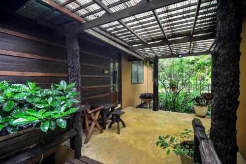 a porch with benches and plants and a pergola at The Spa Koh Chang Resort in Ko Chang