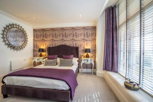 a bedroom with a large bed with purple sheets and pillows at 31 Cocoa Suites in York
