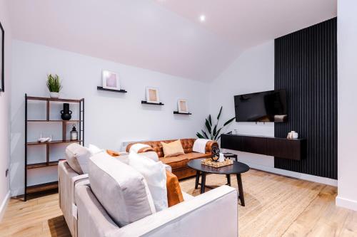 uma sala de estar com um sofá e uma televisão em South Street Apartments em Hull