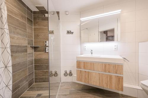 een badkamer met een wastafel en een douche bij Ferienwohnpark Immenstaad am Bodensee Zwei-Zimmer-Apartment 49 18 in Immenstaad am Bodensee
