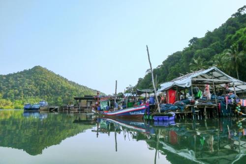 a group of boats parked on the water with mountains at The Spa Koh Chang Resort in Ko Chang
