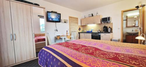 a hotel room with a bed and a kitchen at Ferienzimmer Quint nahe Kap Arkona in Altenkirchen