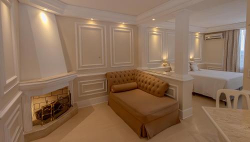 a bedroom with a couch and a bed and a fireplace at Lizon Curitiba Hotel in Curitiba
