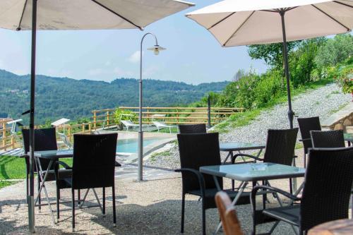 a group of tables and chairs with umbrellas and a pool at Ca Montiglio in Quagliuzzo