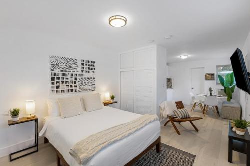 a white bedroom with a bed and a dining room at Lake Ridge Villa in Fort Lauderdale