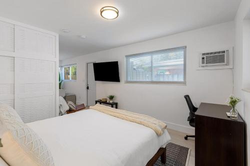 a bedroom with a bed and a desk and a television at Lake Ridge Villa in Fort Lauderdale