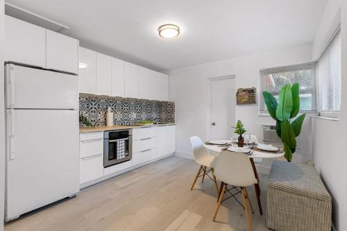 a kitchen with white cabinets and a table and chairs at Lake Ridge Villa in Fort Lauderdale