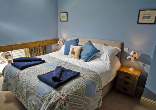 a blue bedroom with a bed with blue pillows at Spring Cottage in Kendal