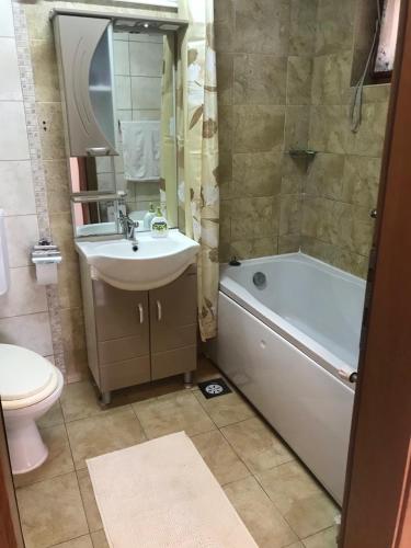 a bathroom with a sink and a tub and a toilet at Sunny Luxury Apartment 2BDR in Bitola