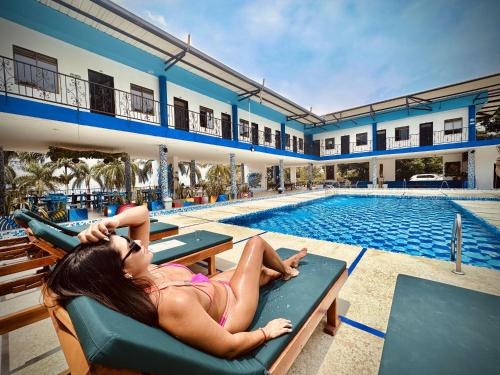 a woman laying on a chair next to a swimming pool at Hotel Villa Alicia in San Jerónimo