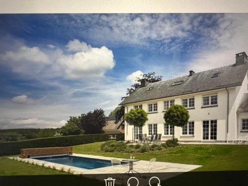 a large white house with a swimming pool in the yard at Oneux Village in Theux