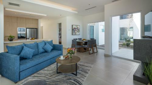a living room with a blue couch and a table at Costa Divina LV 12 Brand New by Kivoya in Puerto Peñasco