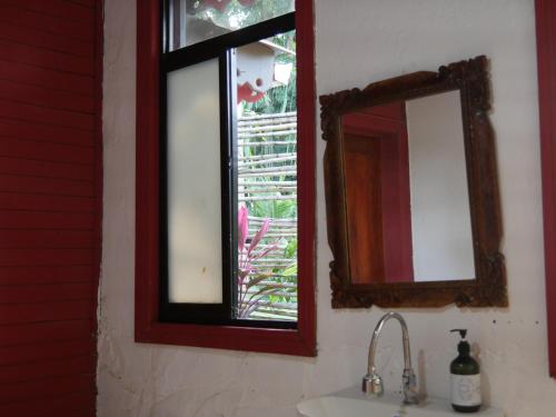 a bathroom with a mirror and a sink at Hotel Mandacarú Puerto Viejo in Puerto Viejo