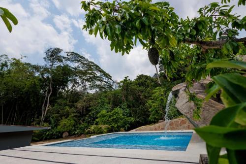 a swimming pool with a waterfall in a resort at El Acuífero in Guaduas