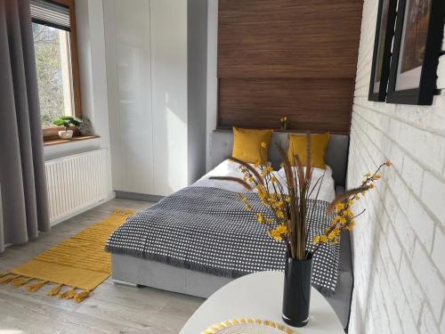 a bedroom with a bed and a vase with flowers on a table at Apartament CARPANO, Ogrodnicza 7 / KARPACZ in Karpacz