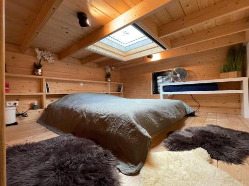 um quarto com uma cama grande num quarto de madeira em Tiny House met Hottub op de Veluwe em Beekbergen