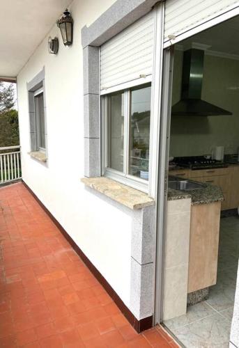 Casa blanca con ventana y cocina en A casa da Sia, en Ribadeo