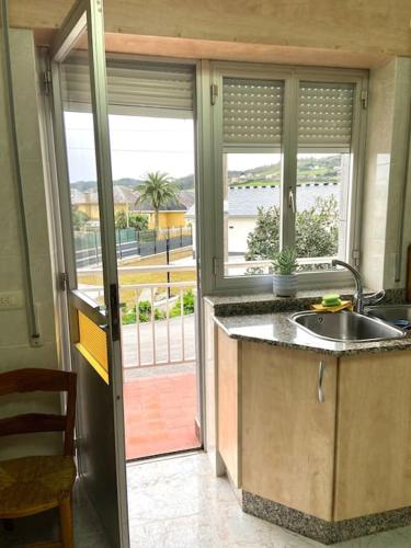a kitchen with a sink and a large window at A casa da Sia in Ribadeo