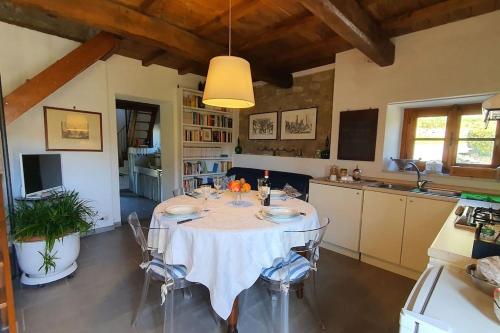 a dining room with a table and a kitchen at Il Cantuccio Proprietà in Pescaglia