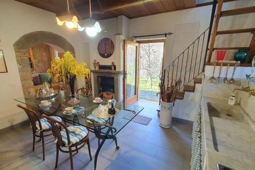 a dining room with a table and chairs and a fireplace at Il Cantuccio Proprietà in Pescaglia