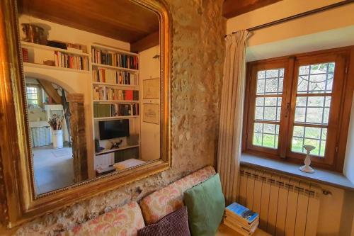 a living room with a mirror and a couch at Il Cantuccio Proprietà in Pescaglia