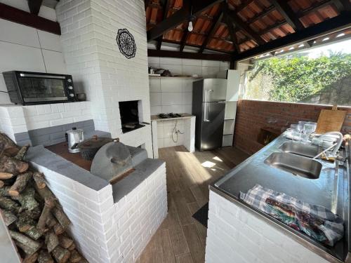uma grande cozinha com um lavatório e um fogão em Vale Beach Pousada em Itajaí