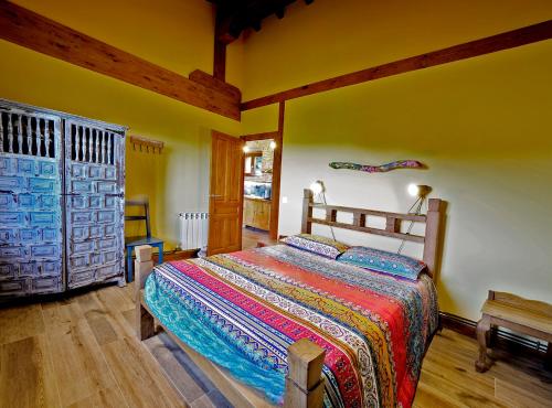 een slaapkamer met een bed met een kleurrijke deken erop bij Precioso apartamento en plena naturaleza in La Cavada