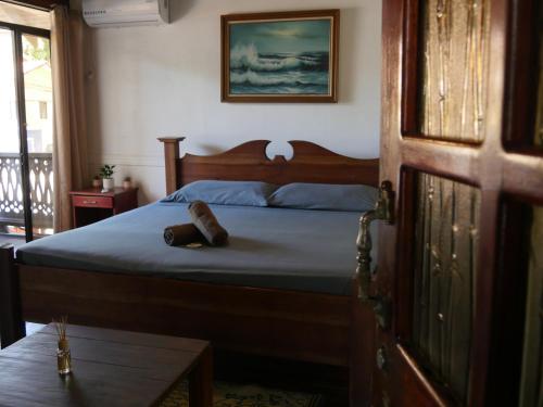 a bedroom with a bed with a wooden head board at Hotel Mandacarú Puerto Viejo in Puerto Viejo