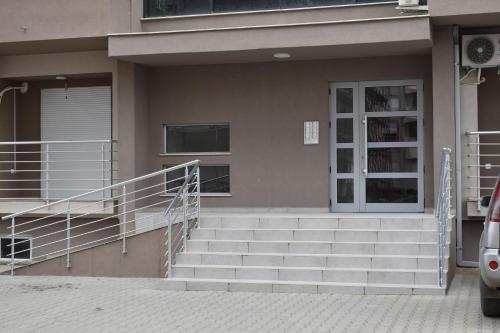 a building with stairs leading to a door and a porch at Allure 23 in Gevgelija